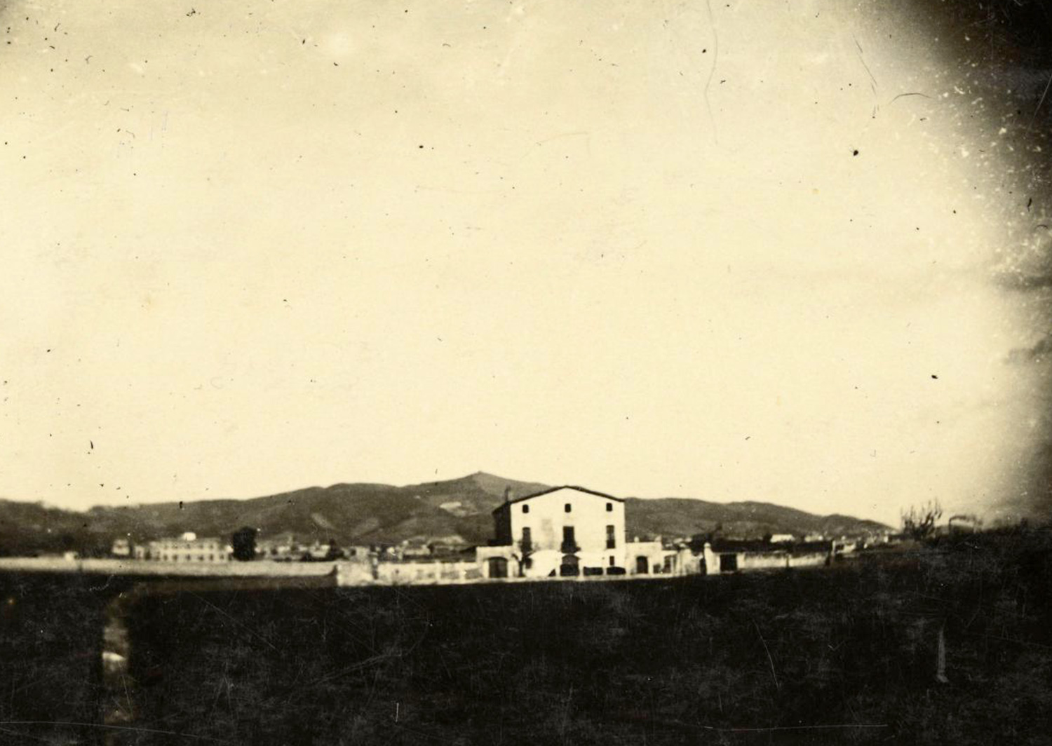 1897 AMDS Terrenys de la masia de can Mantega i al fons edificis del districte de Sants i la serra de Collserola.