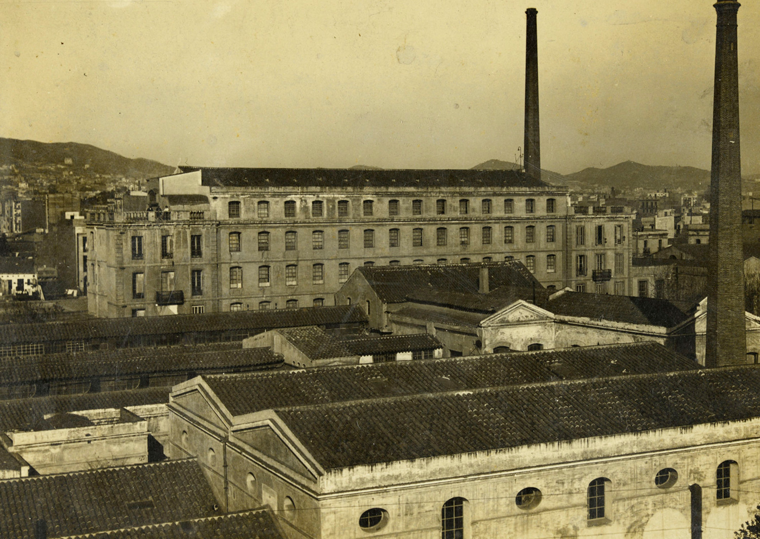 1920 AMDS Vista del conjunt fabril el Vapor Vell i al fons la serra de Collserola.