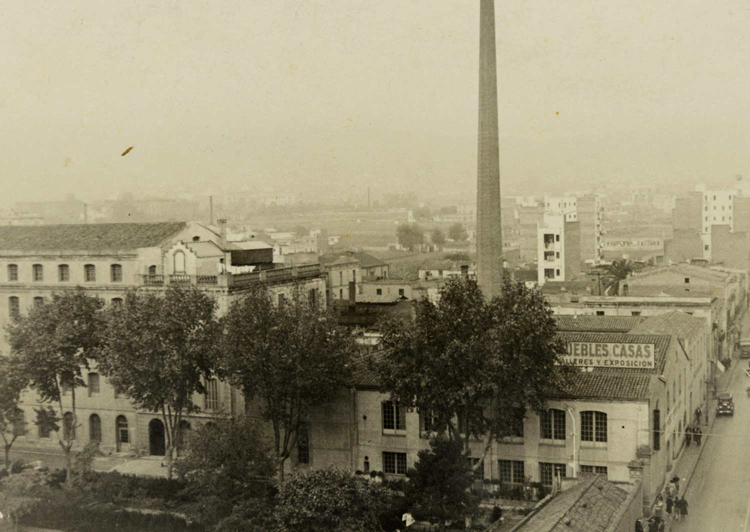 1933 AMDS Conjunt fabril el Vapor Vell situat en el carrer de Galileu. En primer terme, un panell amb l_anunci de _Muebles Casas_. Autor Unió Excursionista de Catalunya